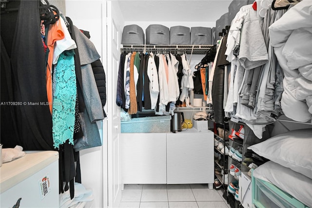 walk in closet with light tile patterned floors