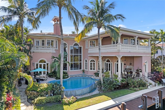 rear view of house with a balcony and a patio