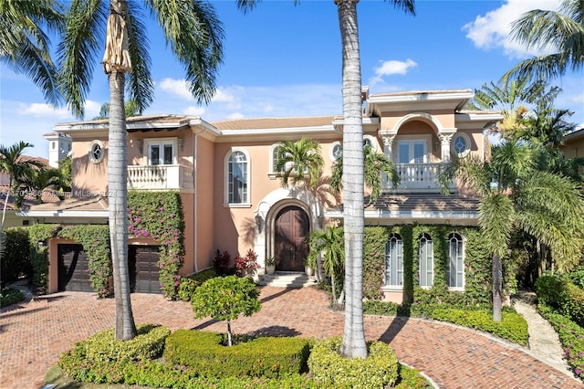 view of front of property featuring a balcony and a garage