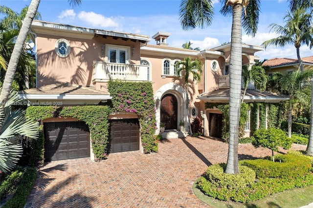 mediterranean / spanish-style house with a garage and a balcony