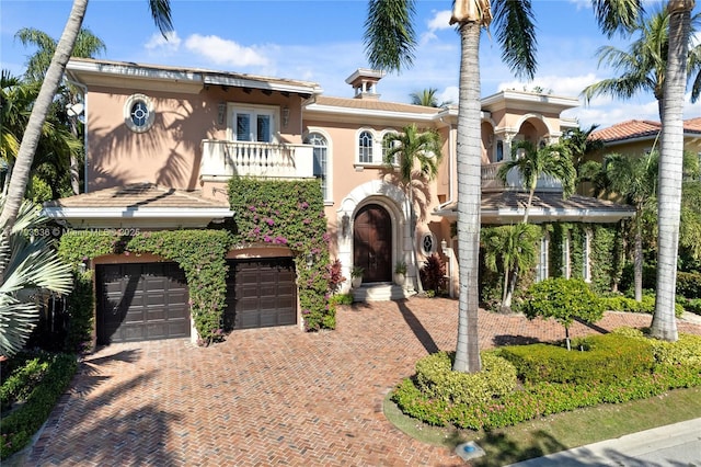 mediterranean / spanish house featuring a garage and a balcony