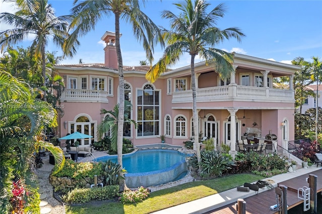 back of property featuring a balcony and a patio area