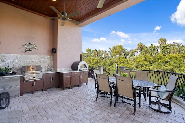 view of patio featuring ceiling fan, an outdoor kitchen, sink, and area for grilling