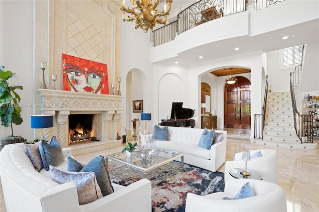 living room with a high ceiling, a notable chandelier, and a fireplace