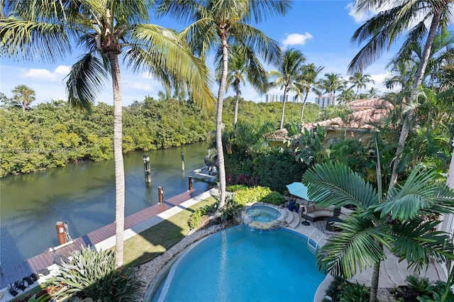 view of swimming pool with an in ground hot tub, a water view, and a dock