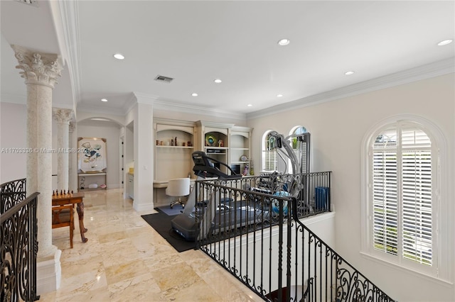 hallway with ornamental molding and decorative columns