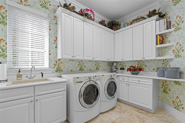 laundry room featuring cabinets, ornamental molding, sink, and washing machine and clothes dryer