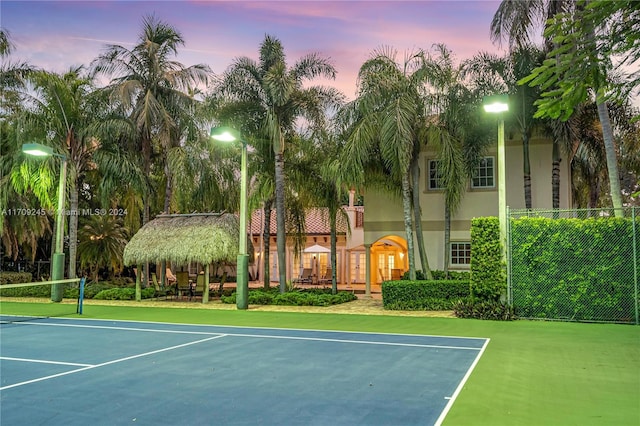 view of tennis court with basketball hoop