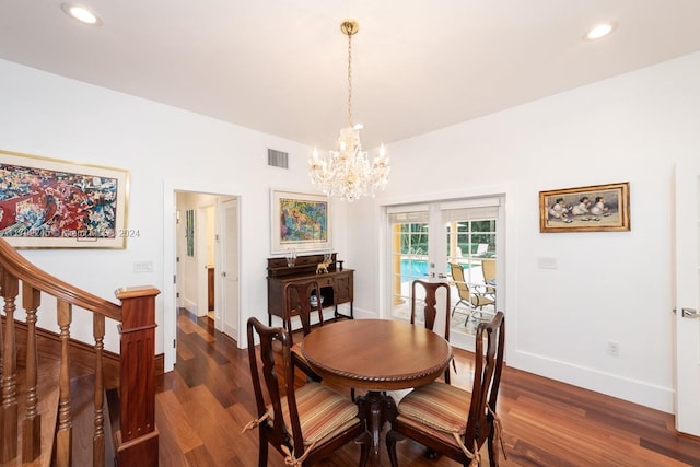 dining area featuring french doors, dark wood-type flooring, and an inviting chandelier