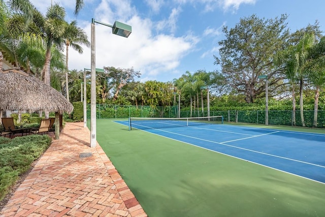 view of tennis court with basketball hoop