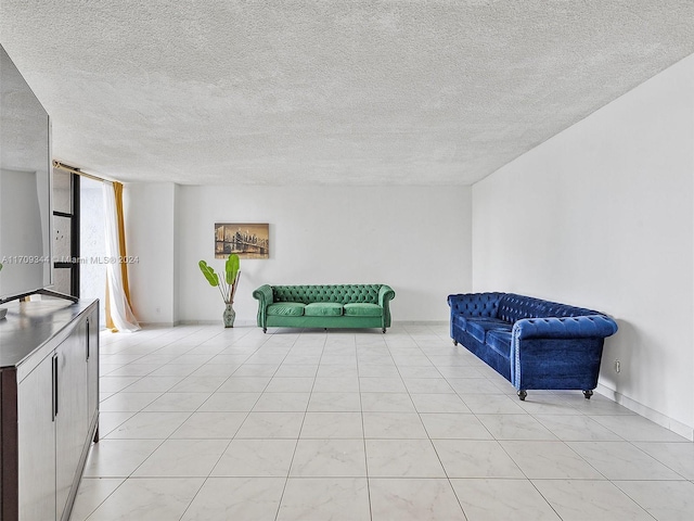 living area featuring a textured ceiling and light tile patterned flooring