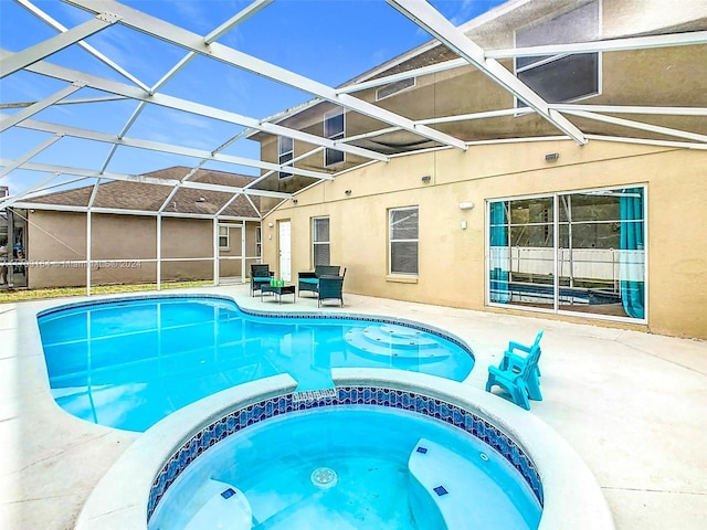 view of pool featuring an in ground hot tub, a patio, and glass enclosure