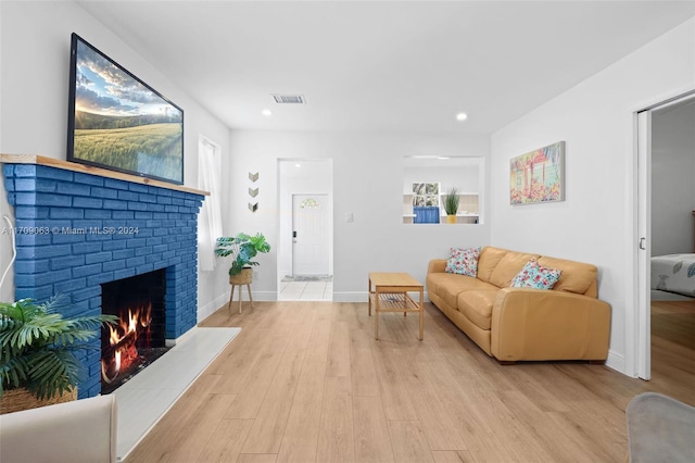 living room with a fireplace and light hardwood / wood-style flooring