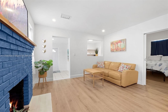 living room with light hardwood / wood-style floors and a fireplace