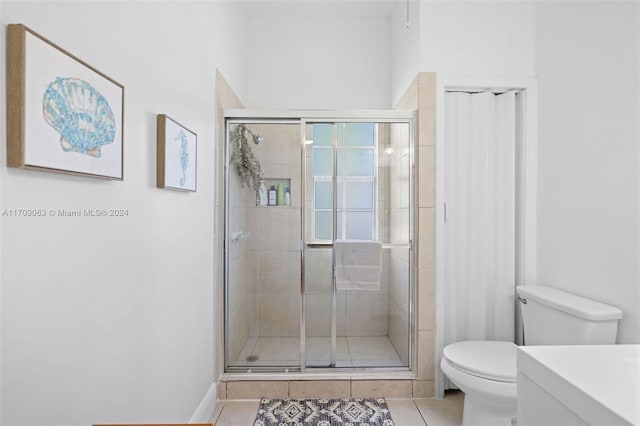 bathroom with tile patterned floors, vanity, an enclosed shower, and toilet