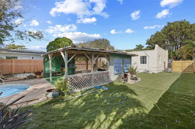 rear view of property featuring a gazebo, a swimming pool side deck, a yard, and cooling unit