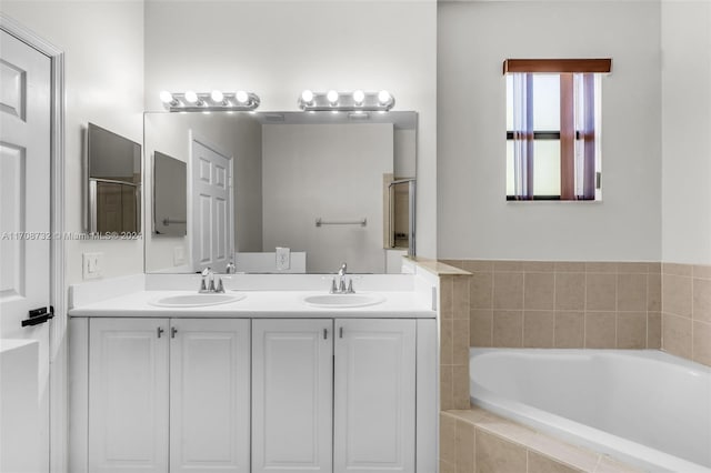 bathroom with vanity and a relaxing tiled tub