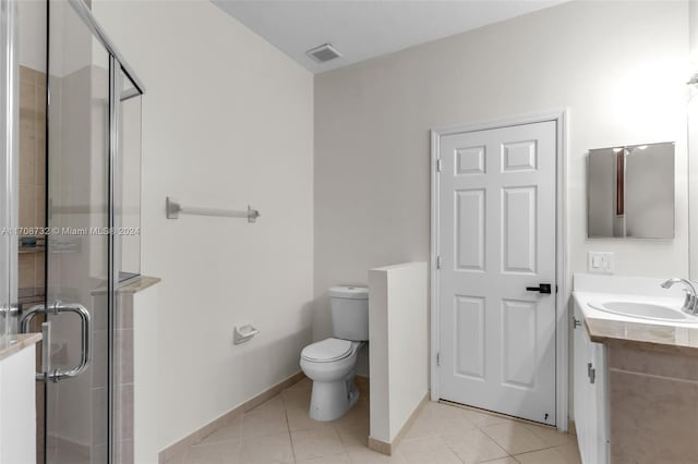 bathroom with tile patterned flooring, vanity, an enclosed shower, and toilet