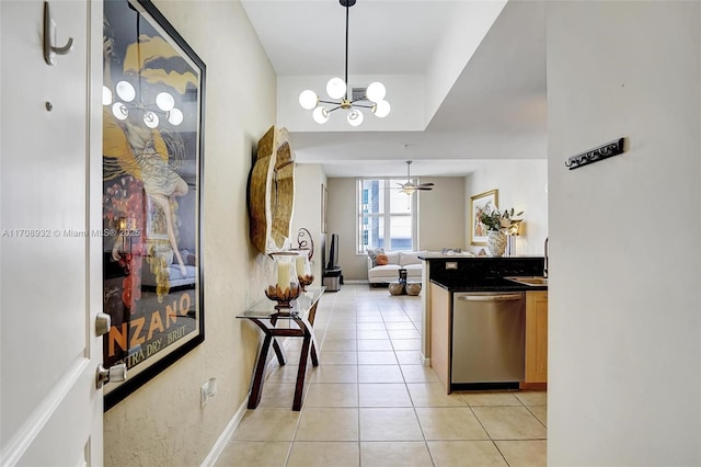 kitchen featuring ceiling fan with notable chandelier, pendant lighting, dishwasher, sink, and light tile patterned floors