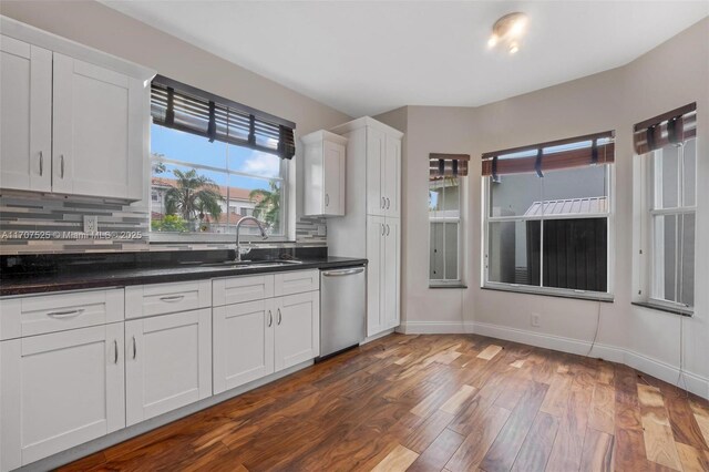 kitchen with white cabinetry, dishwasher, sink, and tasteful backsplash