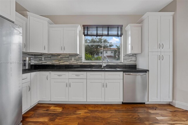 kitchen with sink, dark wood-type flooring, white cabinets, and appliances with stainless steel finishes