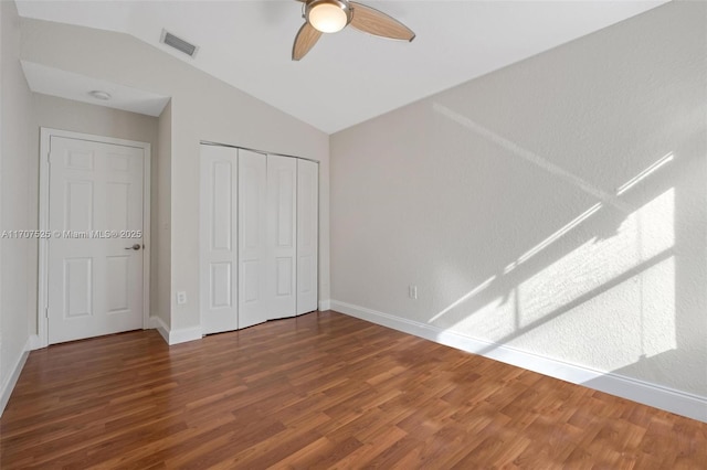 unfurnished bedroom featuring wood-type flooring, vaulted ceiling, ceiling fan, and a closet