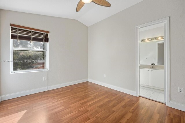 unfurnished bedroom with lofted ceiling, sink, ensuite bath, light hardwood / wood-style flooring, and ceiling fan