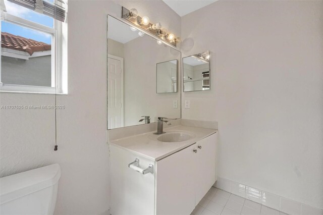 bathroom featuring tile patterned flooring, vanity, and toilet