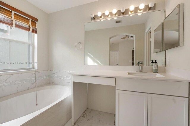 bathroom with vanity and a bath