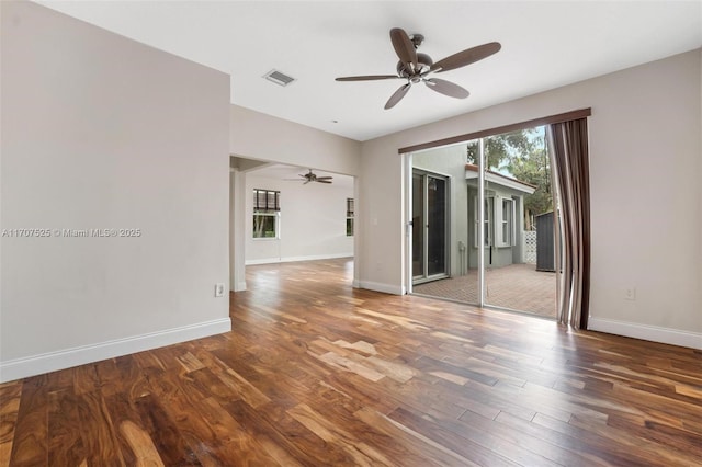 empty room with dark wood-type flooring and ceiling fan