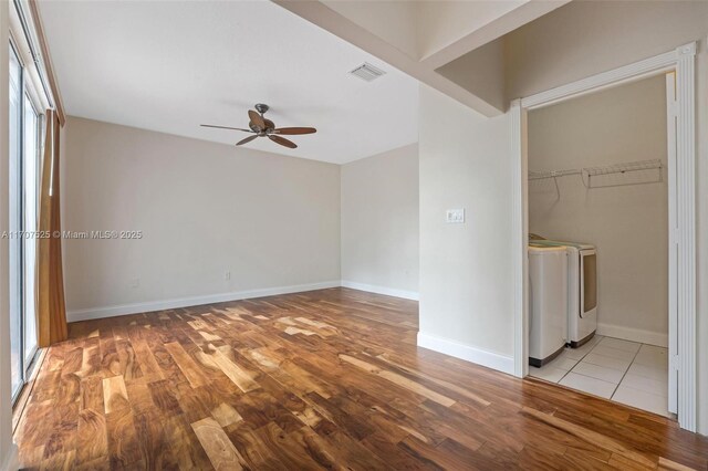 interior space featuring ceiling fan, a spacious closet, washer and clothes dryer, and multiple windows