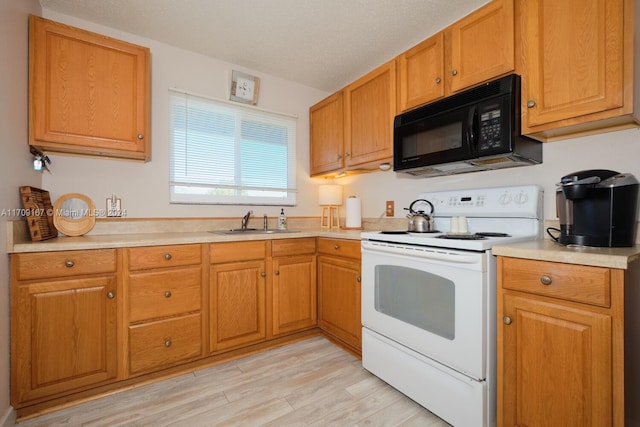 kitchen featuring a textured ceiling, white electric range oven, sink, and light hardwood / wood-style flooring