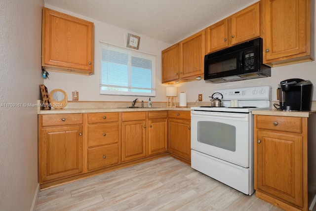 kitchen with white range with electric cooktop, sink, a textured ceiling, and light wood-type flooring