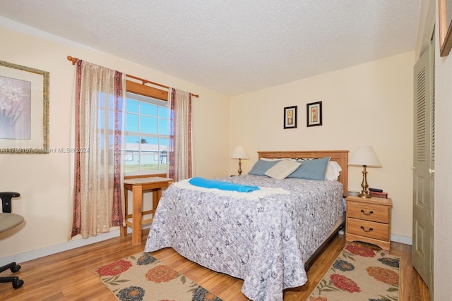 bedroom with a textured ceiling and hardwood / wood-style flooring