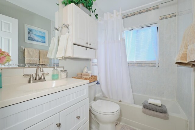 full bathroom featuring vanity, shower / bath combo, and toilet