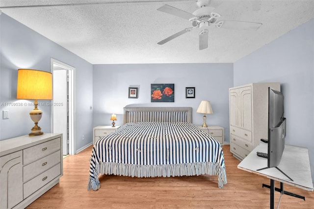 bedroom featuring light wood-type flooring, a textured ceiling, and ceiling fan