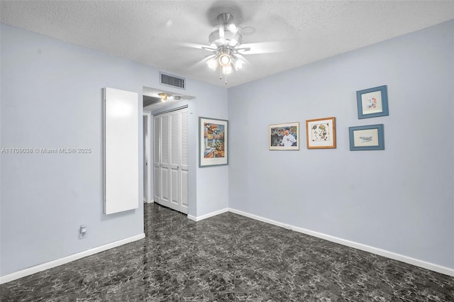 unfurnished bedroom featuring a textured ceiling, ceiling fan, and a closet