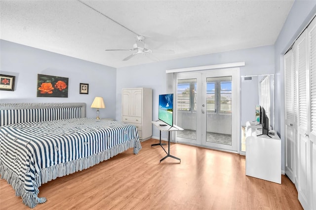 bedroom with ceiling fan, french doors, access to exterior, a textured ceiling, and light hardwood / wood-style flooring