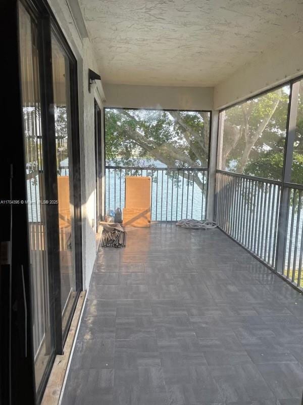 unfurnished sunroom with a water view