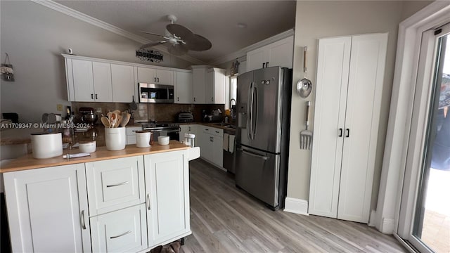 kitchen with white cabinets, stainless steel appliances, plenty of natural light, and ceiling fan