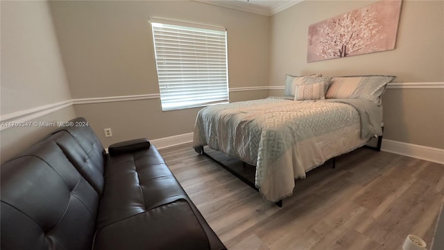 bedroom with hardwood / wood-style flooring and ornamental molding