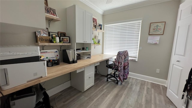 office area with crown molding, light hardwood / wood-style flooring, built in desk, and a textured ceiling