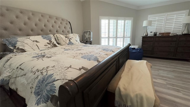 bedroom with crown molding and light hardwood / wood-style flooring