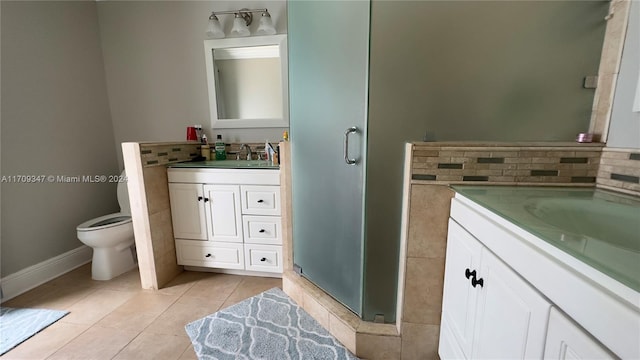 bathroom featuring tile patterned flooring, backsplash, toilet, a shower with door, and vanity