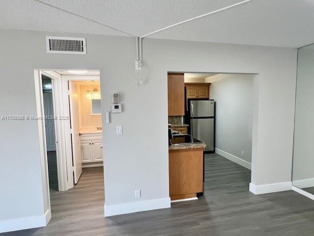 kitchen with stainless steel fridge, dark hardwood / wood-style flooring, pendant lighting, and range