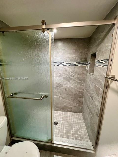 bathroom featuring toilet and an enclosed shower