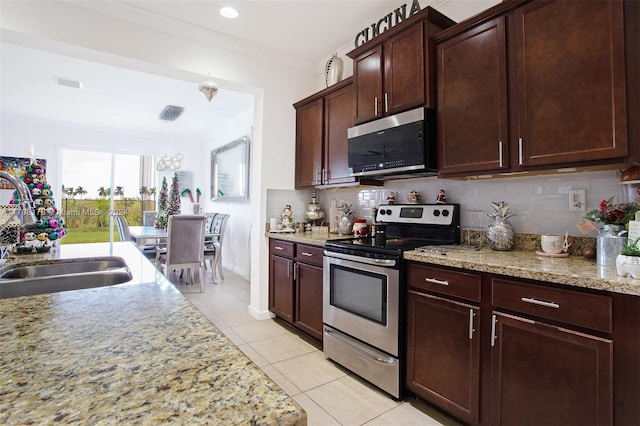 kitchen featuring sink, tasteful backsplash, light stone counters, light tile patterned flooring, and appliances with stainless steel finishes