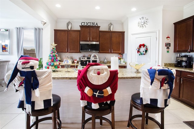 kitchen featuring light stone countertops, stainless steel appliances, and ornamental molding