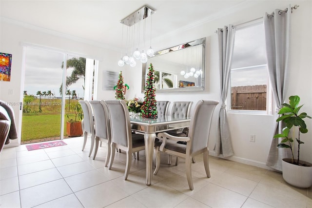 dining space with crown molding, light tile patterned flooring, and an inviting chandelier