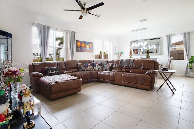 tiled living room with ceiling fan and ornamental molding